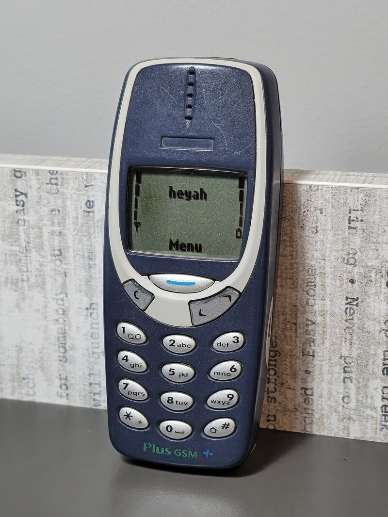 A dark blue Nokia 3310 mobile phone standing upright