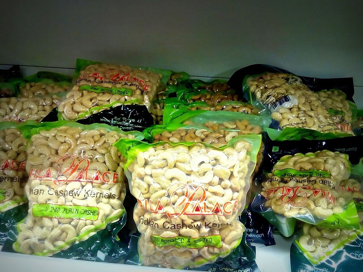 Vacuum-sealed packs of Indian cashew kernels on a shop shelf, labelled 240 plain cashew